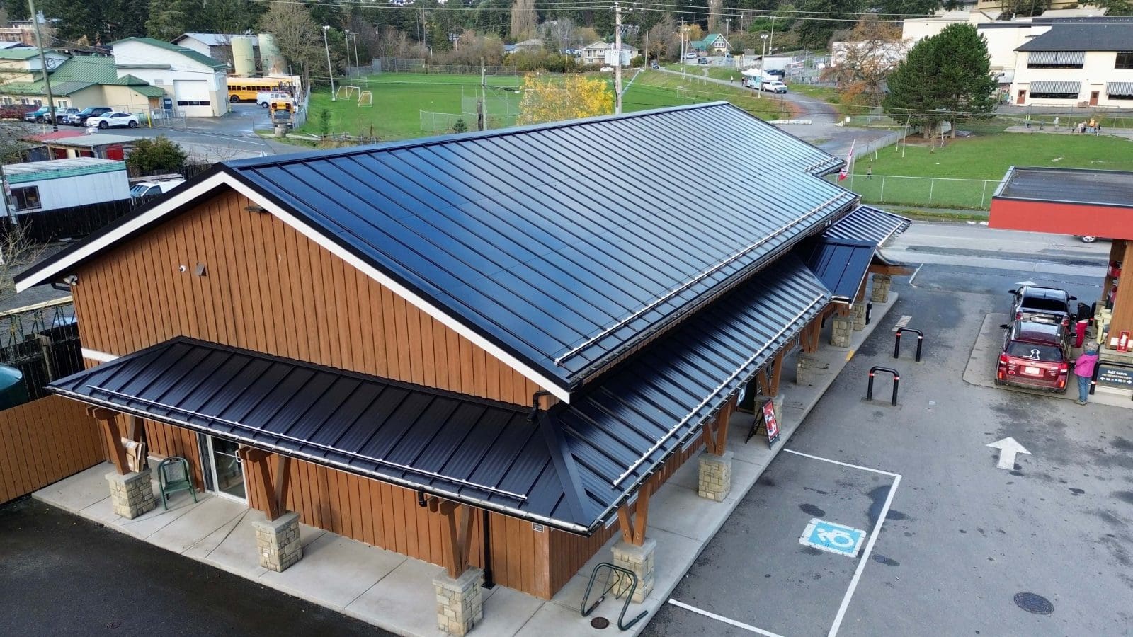 A arial drone photo of a business with BIPV (Building Integrated Photovoltaics) as the roof. A solar panel roof. In Salt Spring, BC