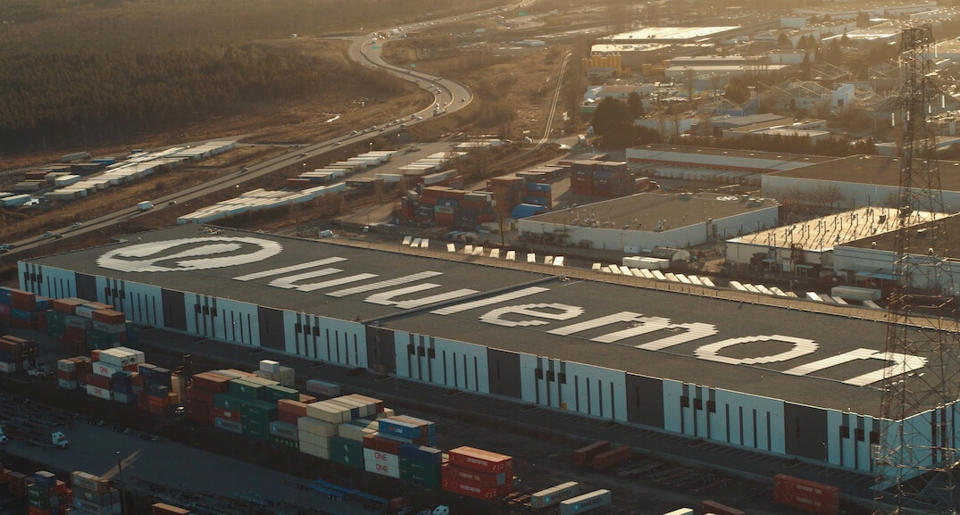 aerial view of the lululemon warehouse with solar panels on the roof in the shape of the logo.