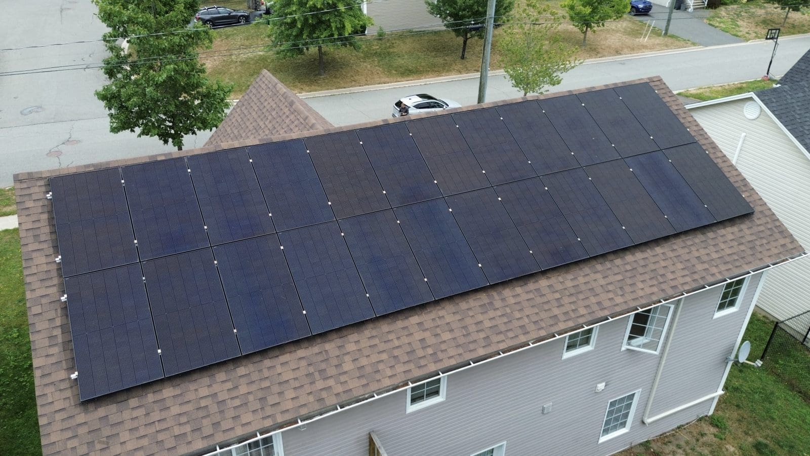 An aerial view of solar panels on the roof of a home.